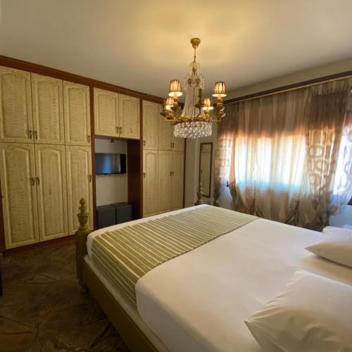 a bedroom with a large bed and a chandelier at Royal stylish view apartment in Koropíon