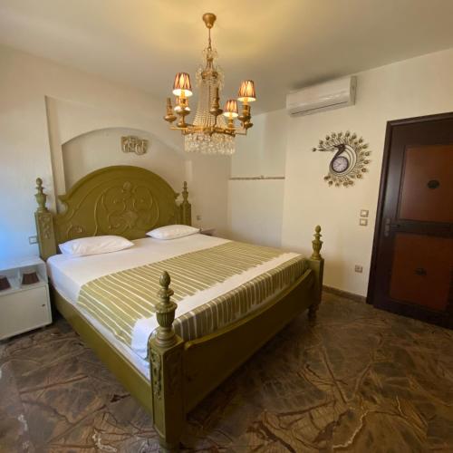 a bedroom with a large bed and a chandelier at Royal stylish view apartment in Koropíon