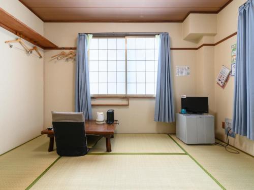 a room with a desk and a window and a table at Tabist Hamanako no Yado Kosai in Kosai