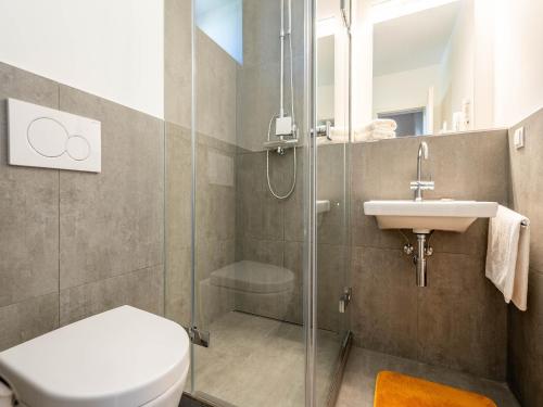 une salle de bains avec douche, toilettes et lavabo dans l'établissement Feriendorf Rugana - Klassik Ferienwohnung mit 2 Schlafzimmern und 2 Terrassen D55, à Dranske