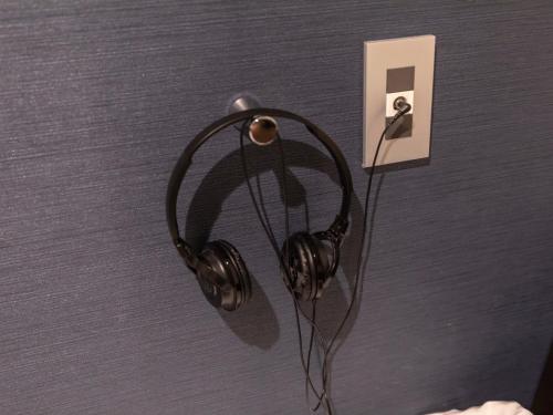 a pair of headphones hanging on a wall at Tabist Hotel Smart Sleeps Oita Station in Oita