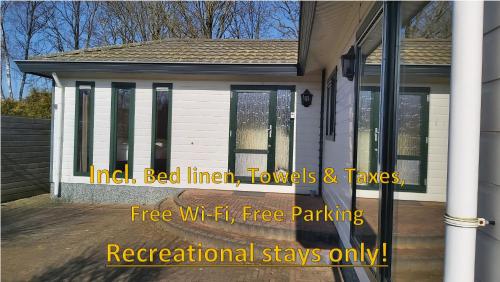 a house with a sign that says free wi fi free parking at Ruim familie chalet tot 4 personen op de Veluwe Bungalowpark De Kern in Putten