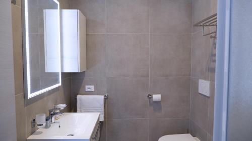 a bathroom with a sink and a toilet and a mirror at Pianomare Riviera Apartments and Rooms in Imperia