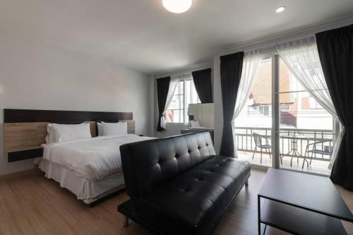 a bedroom with a bed and a couch and a balcony at Basic Line Villa เบสิค ไลน์ วิลล่า in Chiang Mai