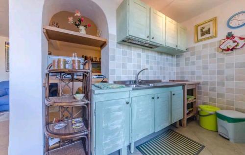a kitchen with blue cabinets and a sink at Luminoso monolocale con vista mare in Porto San Paolo