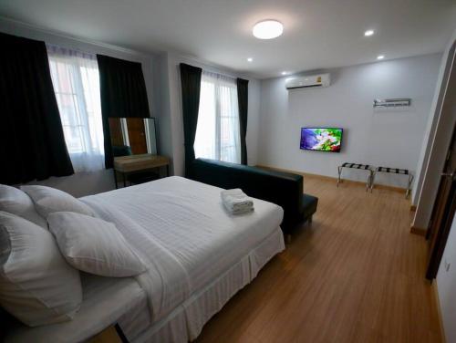 a bedroom with a large bed and a living room at Basic Line Villa เบสิค ไลน์ วิลล่า in Chiang Mai