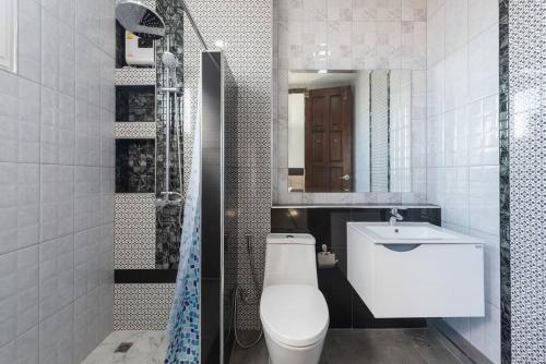 a bathroom with a toilet and a sink and a mirror at Basic Line Villa เบสิค ไลน์ วิลล่า in Chiang Mai
