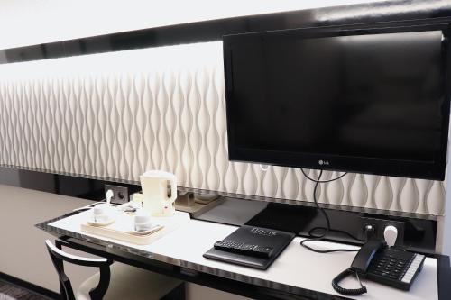 a desk with a computer monitor and a keyboard at Hotel Floris Arlequin Grand-Place in Brussels