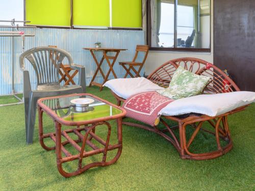 a room with two chairs and a table and a couch at Tabist Hamanako no Yado Kosai in Kosai