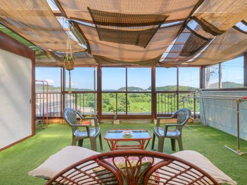 a screened in porch with chairs and a table at Tabist Hamanako no Yado Kosai in Kosai
