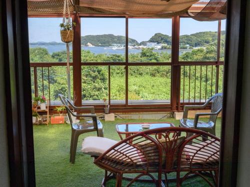 a room with a table and chairs and a large window at Tabist Hamanako no Yado Kosai in Kosai