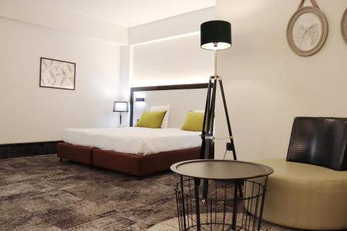 a bedroom with a bed and a table and a chair at Hotel Floris Arlequin Grand-Place in Brussels