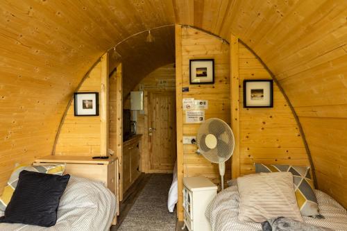 ein Schlafzimmer mit einem Bett in einer Holzhütte in der Unterkunft Ivy hill Glamping Pod in Ennis