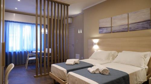 1 dormitorio con 2 camas y toallas. en Pianomare Riviera Apartments and Rooms en Imperia