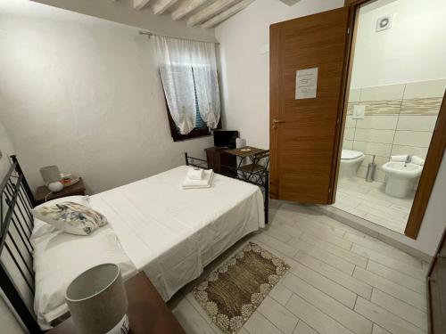 a small bedroom with a bed and a bathroom at Affitta Camere Thomas' in Bagni di Lucca