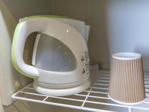 a kitchen appliance sitting on a shelf in a refrigerator at Tabist Nisseiya Beppu Kannawa in Beppu