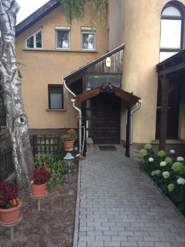 ein Haus mit einem Ziegelsteinweg, der zu einer Garage führt in der Unterkunft PBJ Apartman in Pilisborosjenő