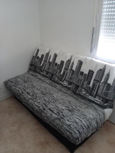 a bed in a room with a picture of a city at Studio - Marina 4 - 13 allée des Pinons - 4-1 in Saint-Jean-de-Monts