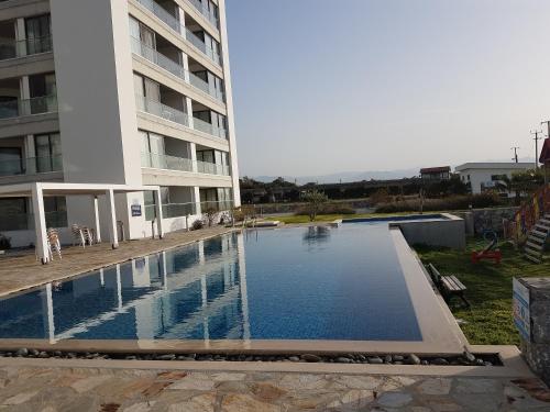 a swimming pool in front of a building at Apartaments Aphrodite in Ghaziveran