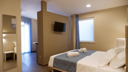 a bedroom with a bed with a tv on the wall at Pianomare Riviera Apartments and Rooms in Imperia