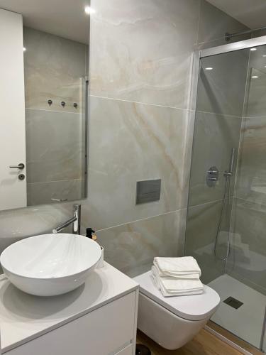 a bathroom with a white sink and a shower at Viamar in Viana do Castelo