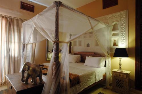 a bedroom with a canopy bed and an elephant statue at Villa Kololo in Kampala