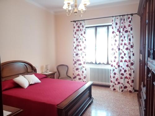 a bedroom with a red bed and a window at B&B BORGHI in Poppi