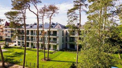 une vue aérienne d'un grand bâtiment blanc avec des arbres dans l'établissement Rezydencja Niechorze 108 Prestige by The Beach z Basenem i SPA, à Niechorze