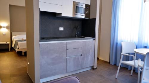 a kitchen with a sink and a table in a room at Pianomare Riviera Apartments and Rooms in Imperia