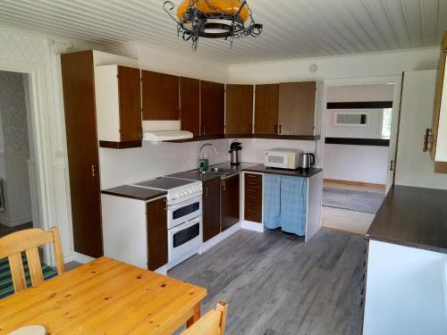 una cucina con armadi in legno, un tavolo e una sala da pranzo di House next door the Arctic Circle a Överkalix