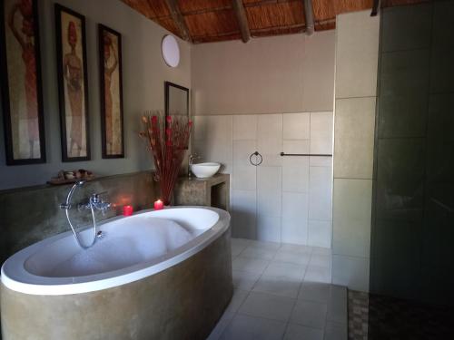 een badkamer met een bad en een douche bij Marloth Bush Retreat in Marloth Park