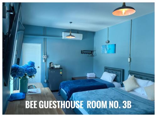 a blue bedroom with two beds and a room with a blue wall at The One House in Nan