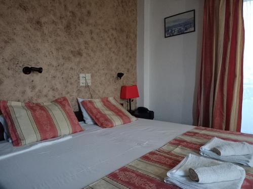 ein Schlafzimmer mit einem großen Bett und roten und weißen Kissen in der Unterkunft Elvira Hotel in Stalida