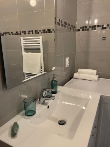 une salle de bain blanche avec un lavabo et un miroir dans l'établissement RIVIERA COTTAGE, à Mandelieu-la-Napoule