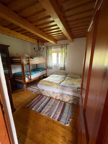 1 dormitorio con 2 camas y ventana en Chata Anna, en Novoť