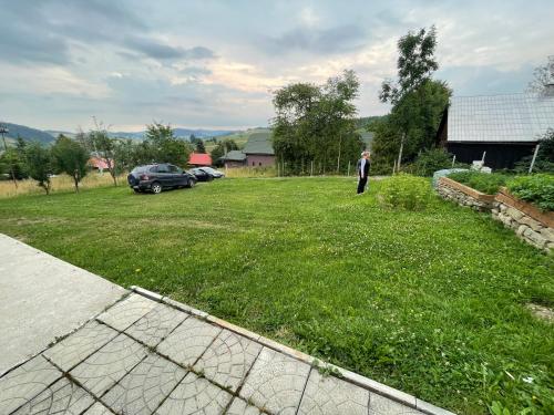 a man standing in the grass in a yard at Chata Anna in Novoť