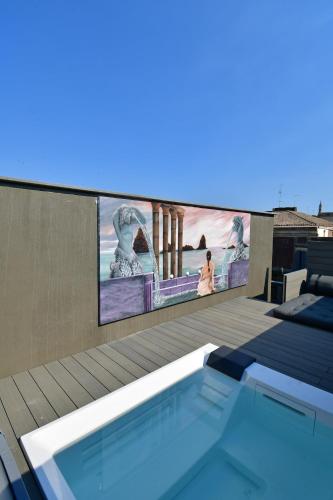 a tv on the side of a building with a swimming pool at San Anton Hotel in Trecastagni
