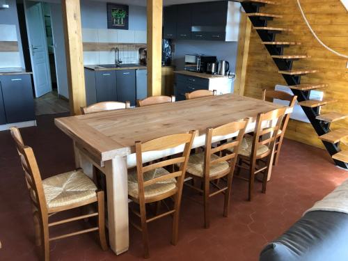 einen Holztisch und Stühle in der Küche in der Unterkunft appartement 8 couchages au lioran rando vtt ski in Le Lioran