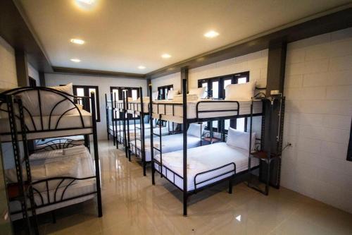 grupa łóżek piętrowych w pokoju w obiekcie Billabong Hostel w mieście Baan Tai
