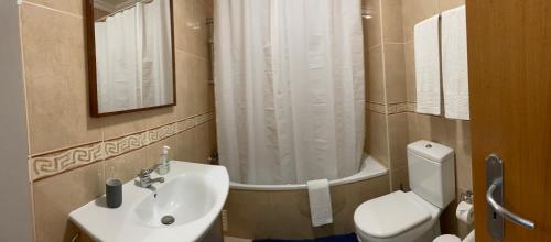 a bathroom with a sink and a toilet and a shower at Vila Praia 7 - Beach & Pool apartment in Alvor