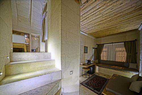 a room with stairs and a table and a window at Kappadoks Cave Hotel in Uchisar