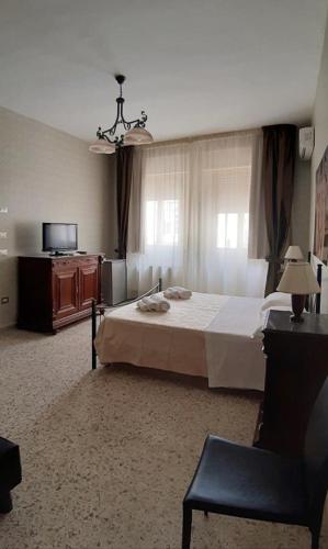 a bedroom with a bed and a dresser and a television at Domus Salentina in Leverano