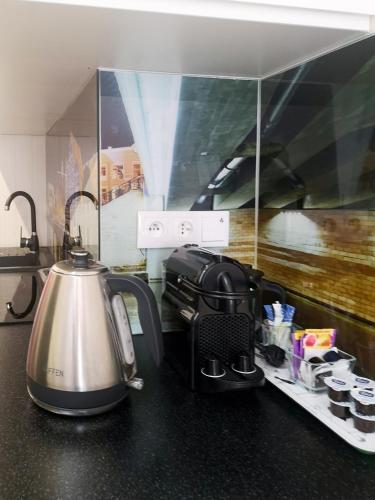 a kitchen counter with a tea kettle and cups at Softly Residence in Bydgoszcz