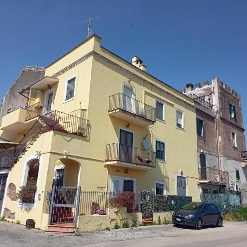a yellow building with a car parked in front of it at La Torre di Barbara in Ardea