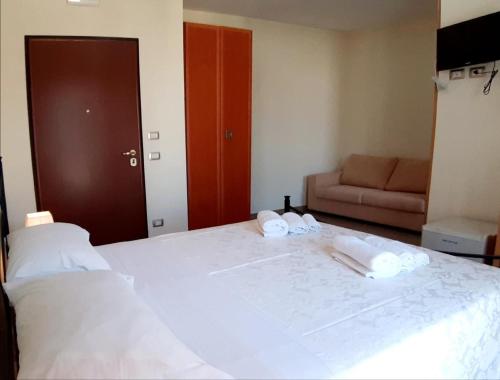 a bedroom with a large white bed with towels on it at Domus Salentina in Leverano