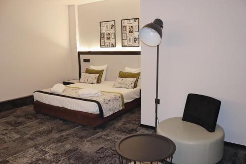ein Schlafzimmer mit einem Bett und einem Stuhl in der Unterkunft Hotel Floris Arlequin Grand-Place in Brüssel