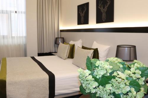 een hotelkamer met een bed met bloemen erop bij Hotel Floris Arlequin Grand-Place in Brussel
