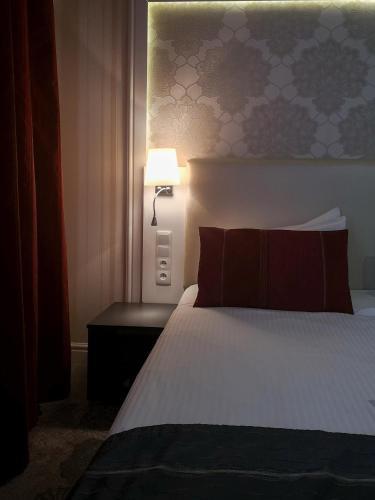 a hotel room with a bed with a lamp on it at Softly Residence in Bydgoszcz