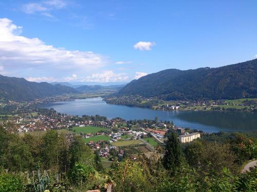 a view of a town and a lake with mountains at Ferienwohnungen Vidoni in Bodensdorf