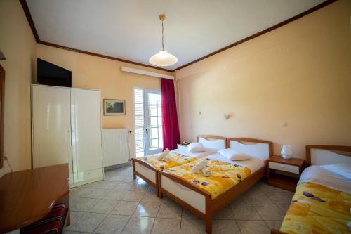 a bedroom with two beds and a window at ΞΕΝΟΔΟΧΕΙΟ ΠΑΠΑΝΑΓΙΩΤΟΥ in Neraïdochóri